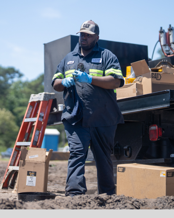 Gloved worker in uniform stands by truck with boxes outdoors.