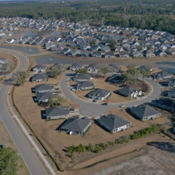 Aerial view of suburb with curved streets and houses.