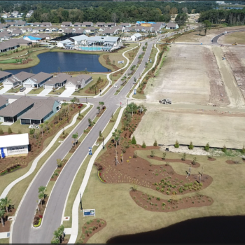 Aerial view: finished homes, landscaping, ponds, and construction nearby.