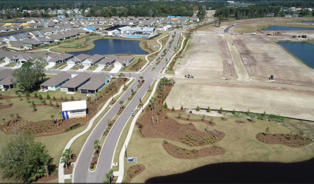 Aerial view: finished homes, landscaping, ponds, and construction nearby.