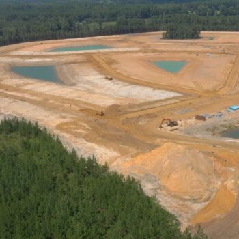 Aerial view of construction site with cleared land and ponds.