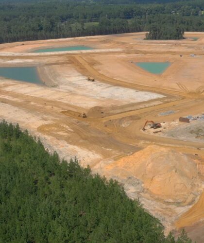 Aerial view of construction site with cleared land and ponds.