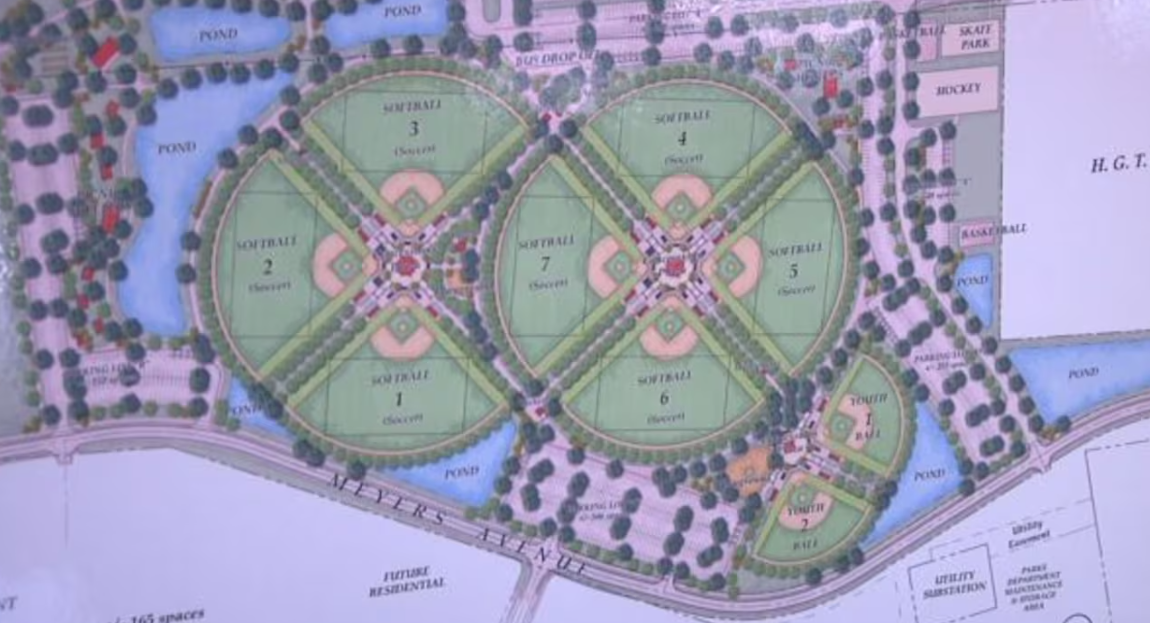 Aerial view of park with softball fields, ponds, and trees.